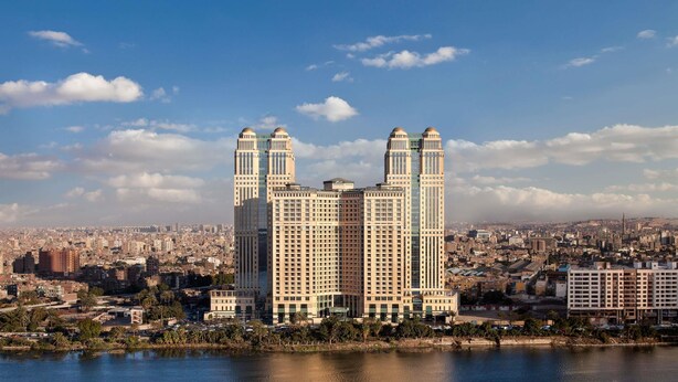 Un edificio alto con una fachada simétrica y dos torres destacadas en la parte superior.