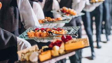 Waitstaff carrying trays of food.