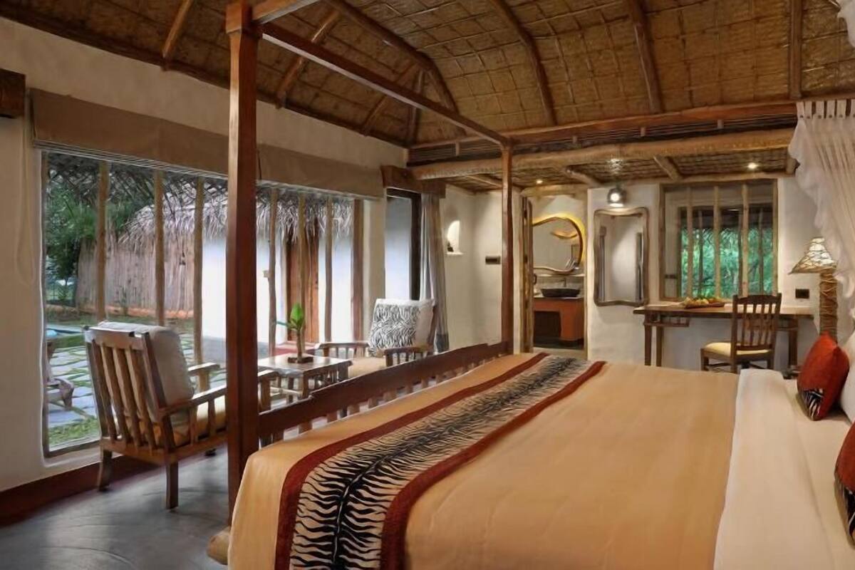 Ein geräumiges Schlafzimmer mit einem großen Bett, einem Essbereich und Blick ins Freie.