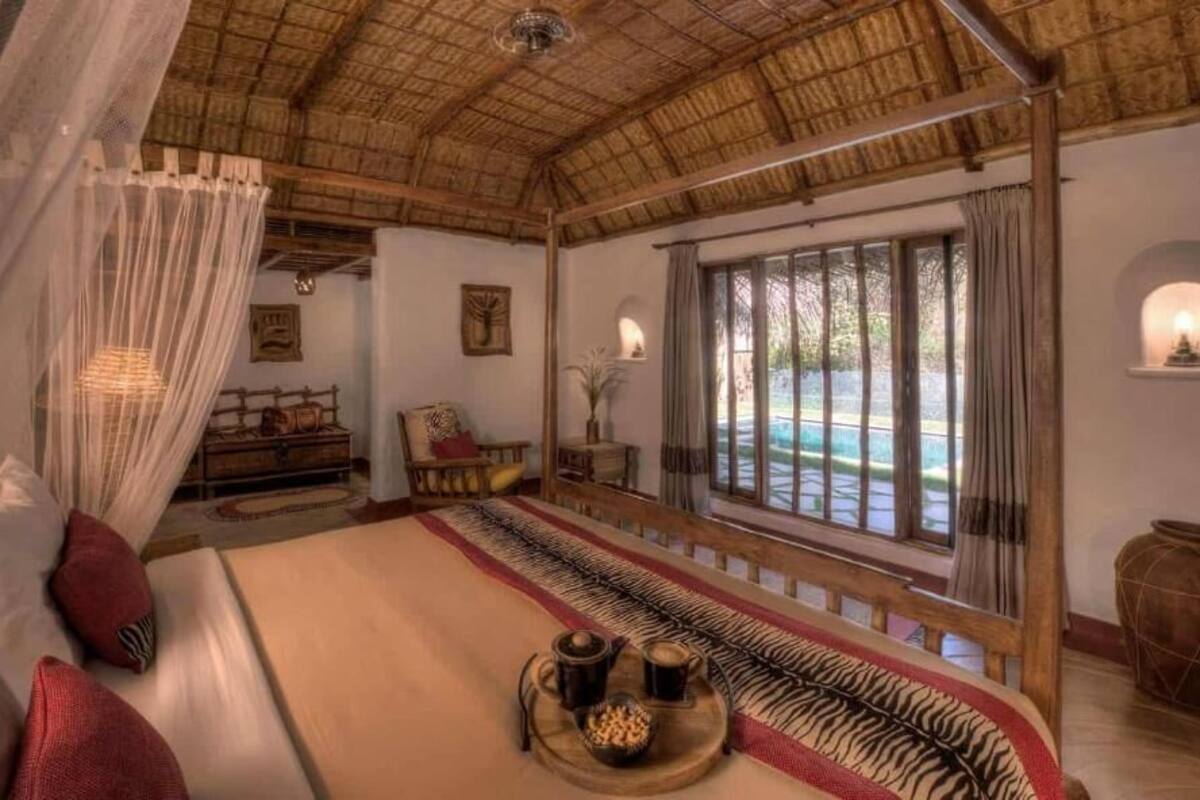 Ein Zimmer mit einem Bett, einem Esstisch, einem Fenster mit Blick und einem Deckenventilator.