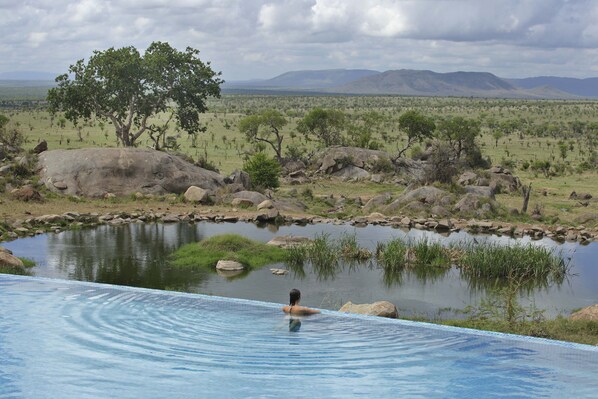 Una piscina al aire libre, tumbonas