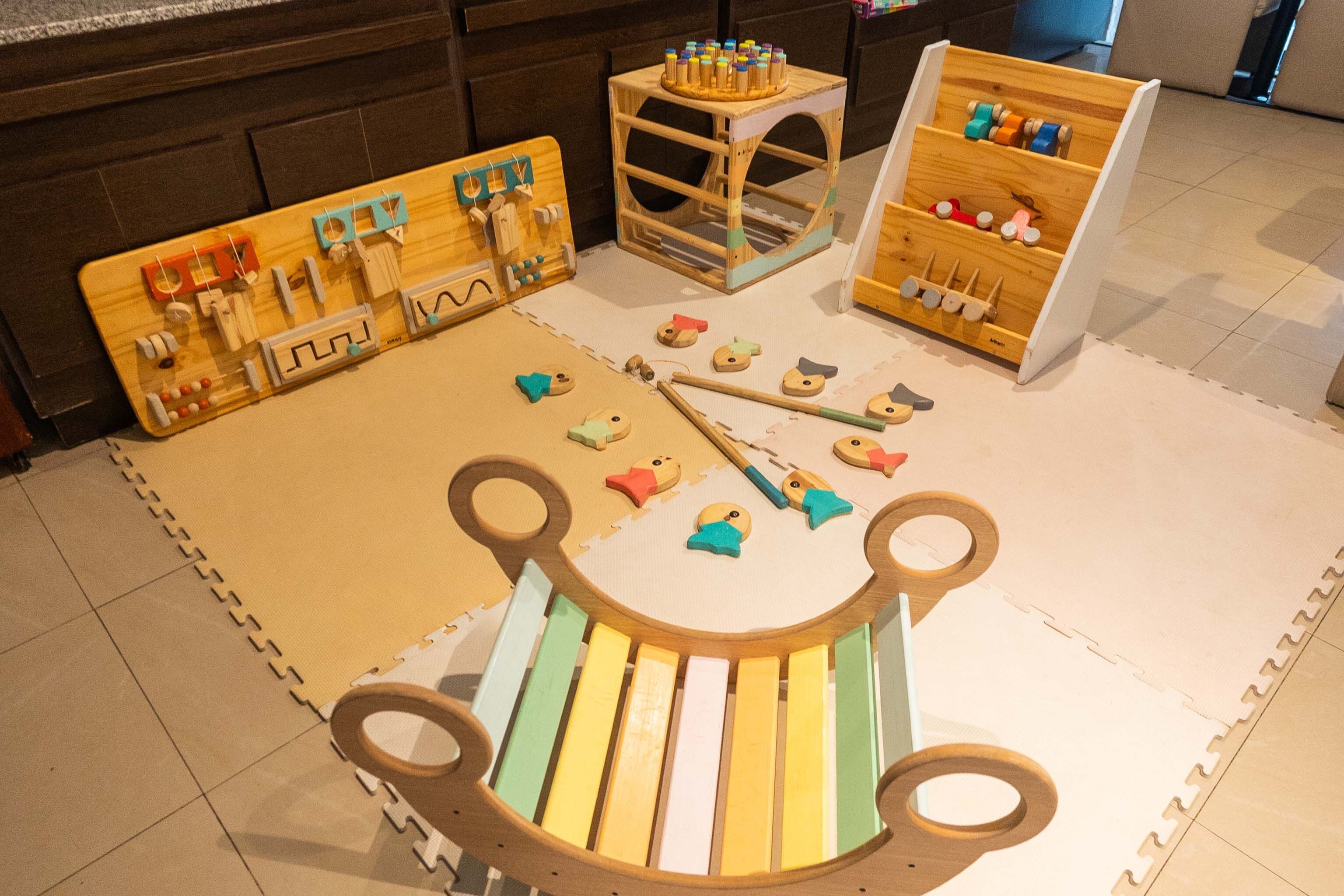 A play area with wooden toys and a mat.