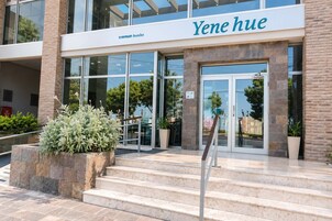 Entrada de un hotel con un letrero que dice 'Yene hue' y 'tremun hotels'.