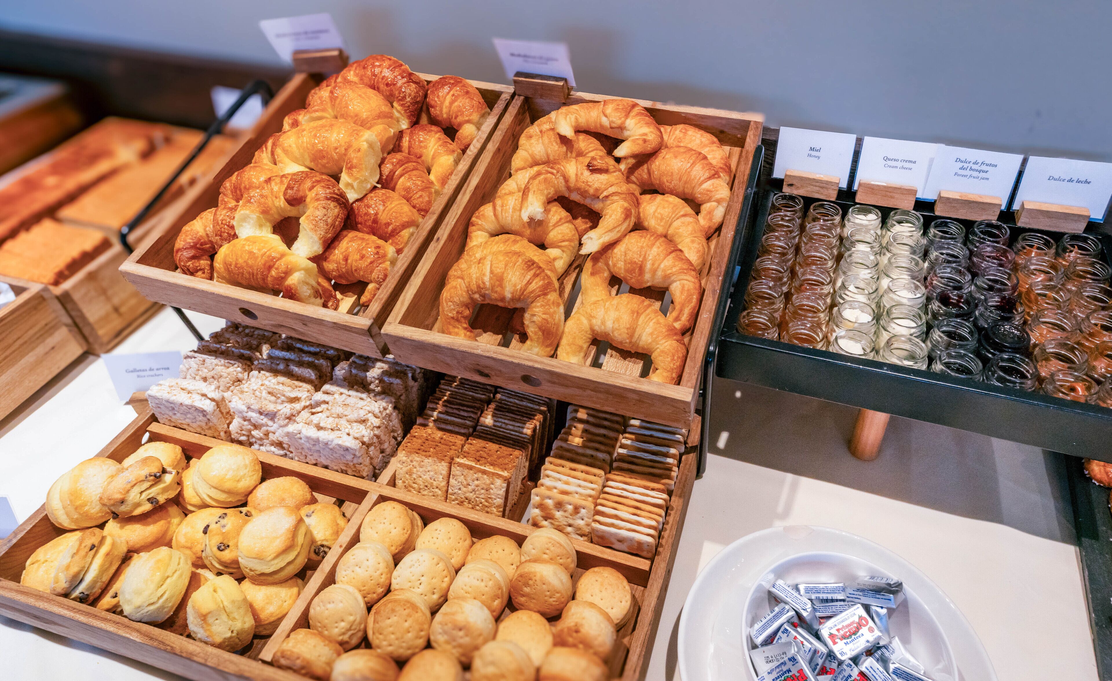 A bakery display with various baked goods including croissants, muffins, and pastries.