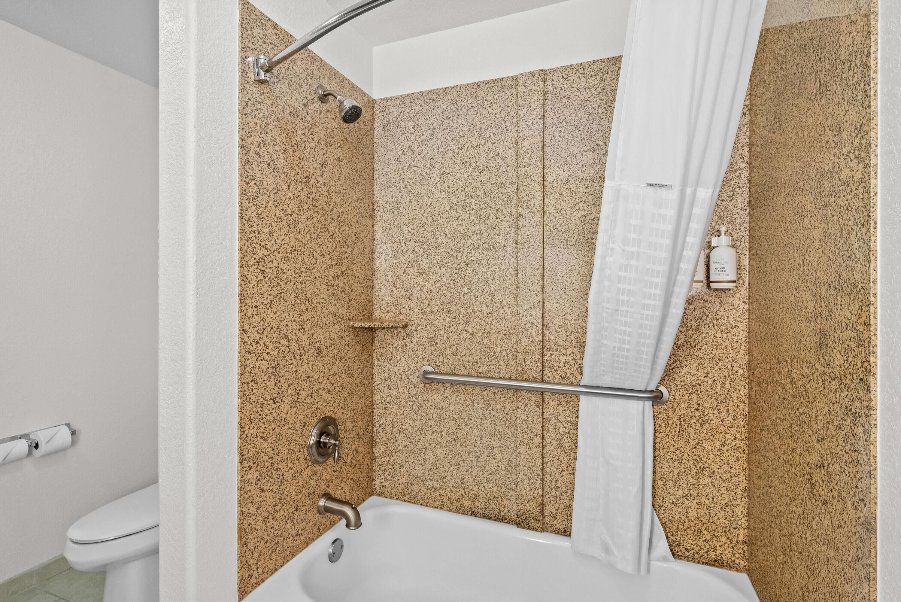 Un baño con bañera, ducha e inodoro.