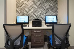 A workspace with two desks, each with a computer and a printer.