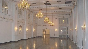 A spacious hall with a polished floor, ornate chandeliers, and wall sconces. - The George Washington Hotel (Washington)