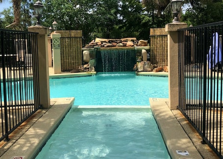Una piscina al aire libre de temporada, sombrillas