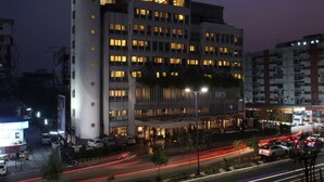 A multi-story hotel with illuminated windows and a prominent sign on the top. - Hotel Express Towers (Vadodara)