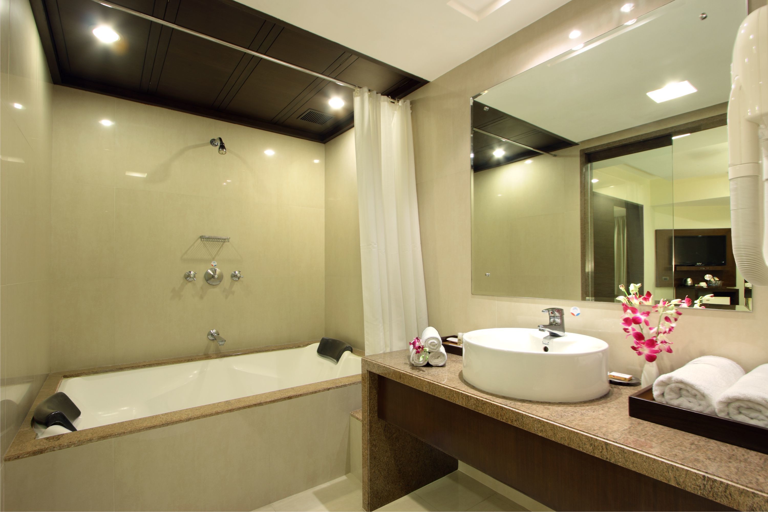 Un baño moderno con bañera, lavabo y un espejo grande.