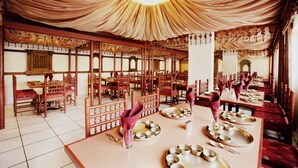 A traditional restaurant with wooden furniture and tables set for dining. - Hotel Express Towers (Vadodara)