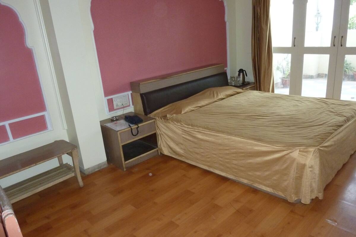 A bedroom with a bed, bedside table, and a bench.