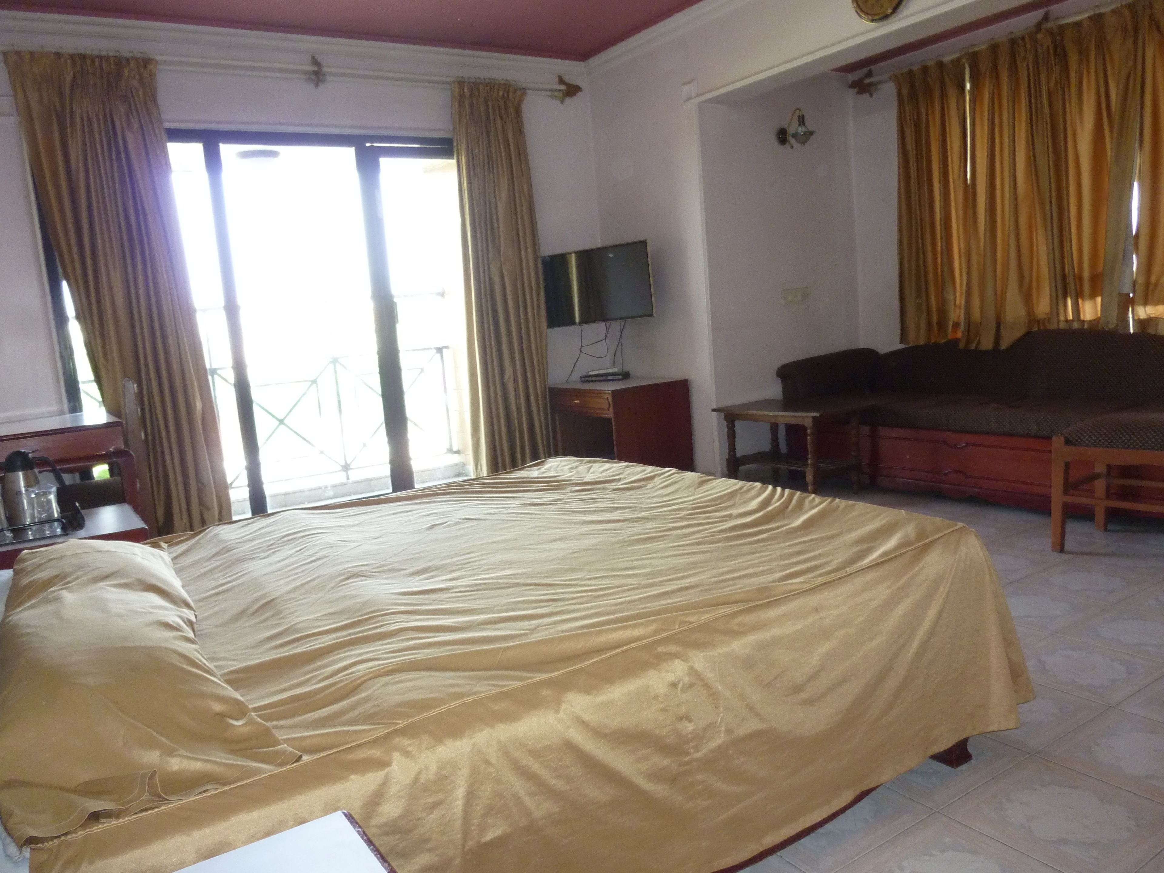 Une chambre d’hôtel avec un grand lit, un bureau avec un ordinateur, un canapé et une télévision.