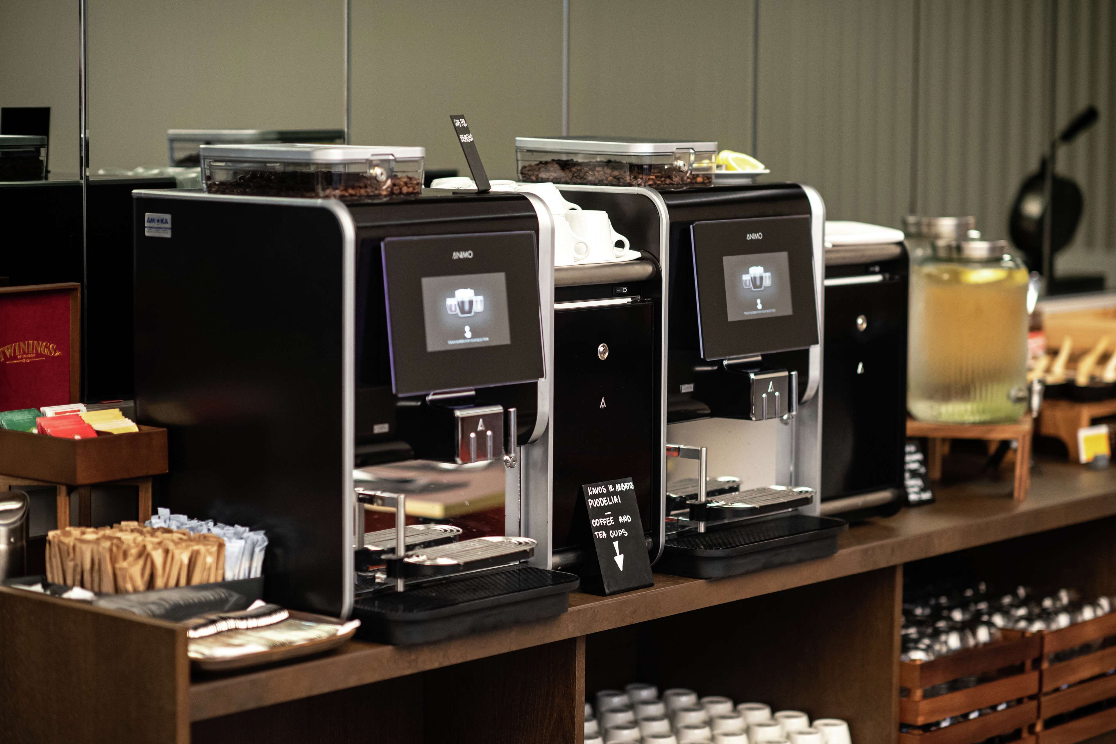 A coffee station with multiple espresso machines, a coffee grinder, and a variety of coffee beans.