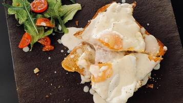 A plate with a fried egg and toast, accompanied by a side salad with cherry tomatoes.