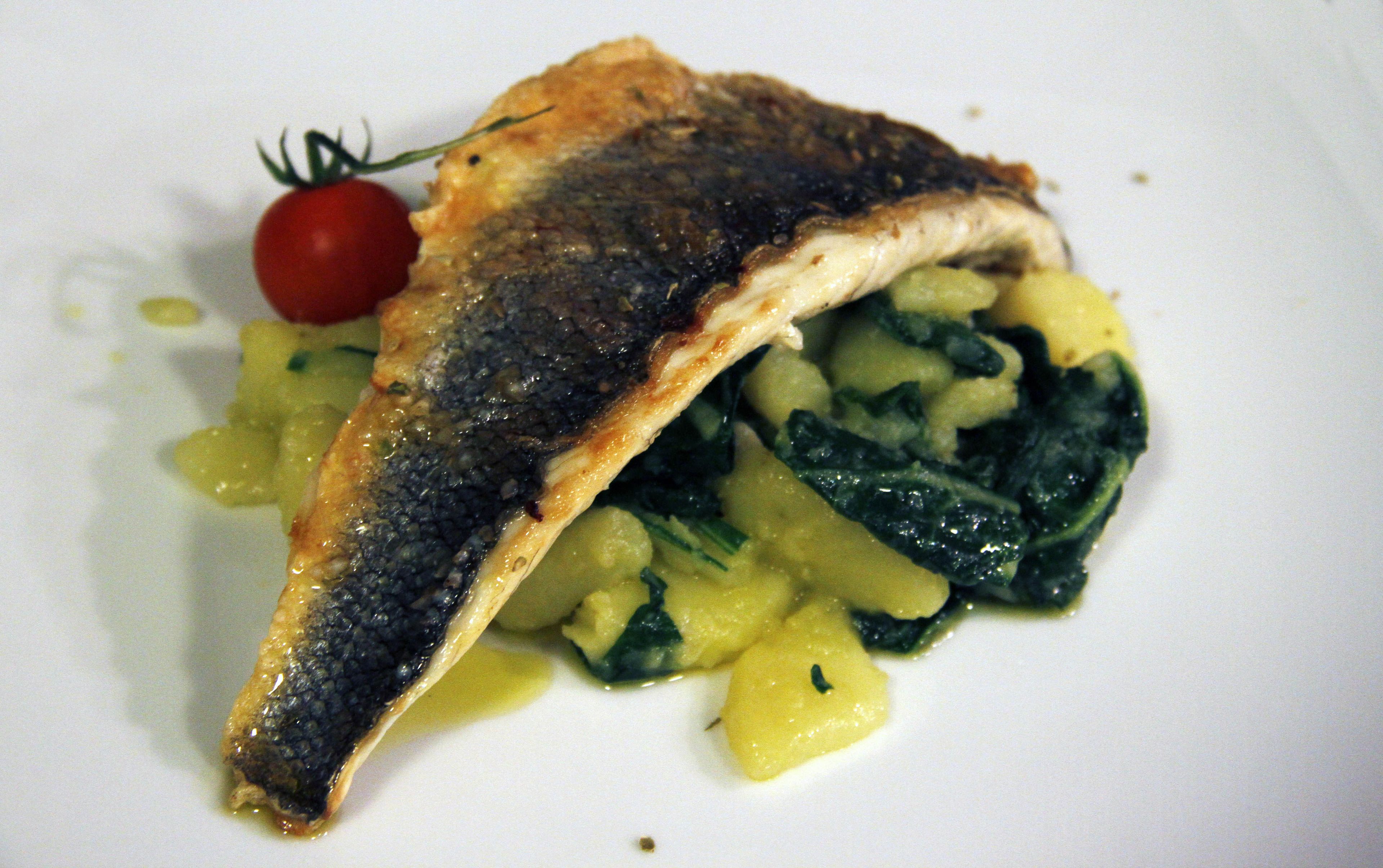 Un plat composé de poisson, de pommes de terre et de légumes verts, servi dans une assiette.