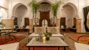 Un interior espacioso con una zona de estar central, arcos y decoración tradicional.