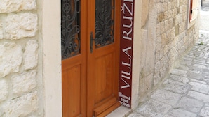 A stone building with a wooden door labeled "Villa Ruizica" and "Sobe Rooms." - Guesthouse Ruzica (Trogir)