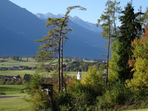 Un paisaje rural con una iglesia, montañas y cielo despejado.
