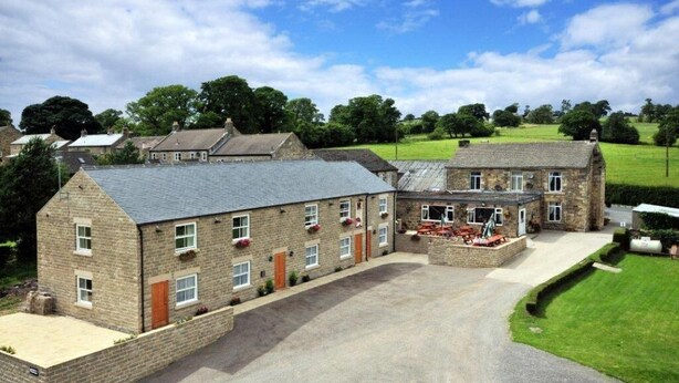 A large stone building with multiple windows and a paved driveway. - Black Swan Inn (Ripon)