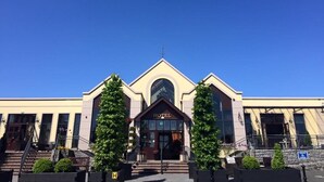 A hotel with a symmetrical facade, a central entrance with a large arched doorway, and a sign above the entrance reading "HOTEL". - Four Seasons Hotel & Leisure Club Monaghan (Monaghan)