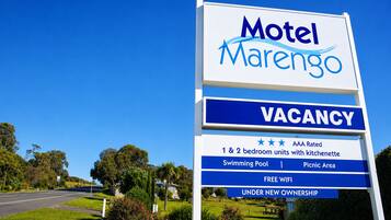 A sign for Motel Marengo advertising a vacancy, 1 & 2 bedroom units with kitchenette, swimming pool, picnic area, free WiFi, and under new ownership.