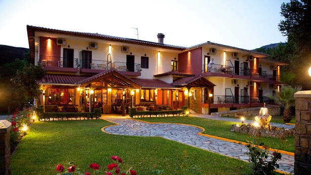 A two-story building with a tiled roof, multiple balconies, and a central courtyard with a fountain. - Spanias (Kalabaka)