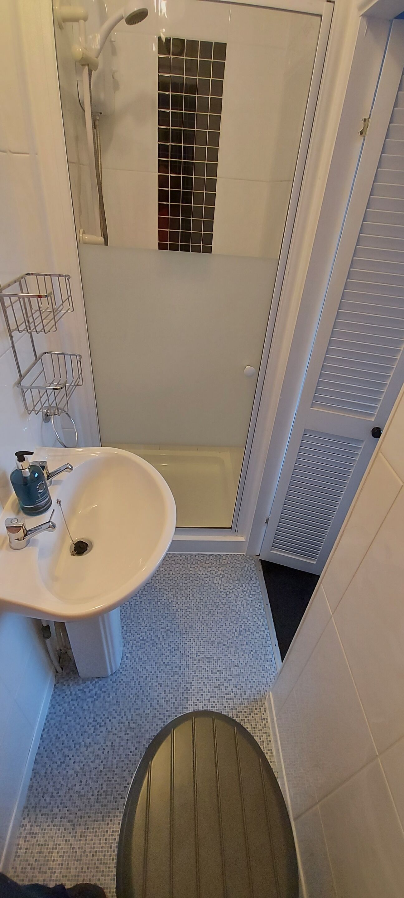 A bathroom with a shower, sink, and toilet.