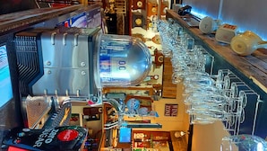 A bar area with a large beer tap, multiple wine glasses, and a variety of bottles and bottles. - Sportsmans Valley Hotel (Liskeard)