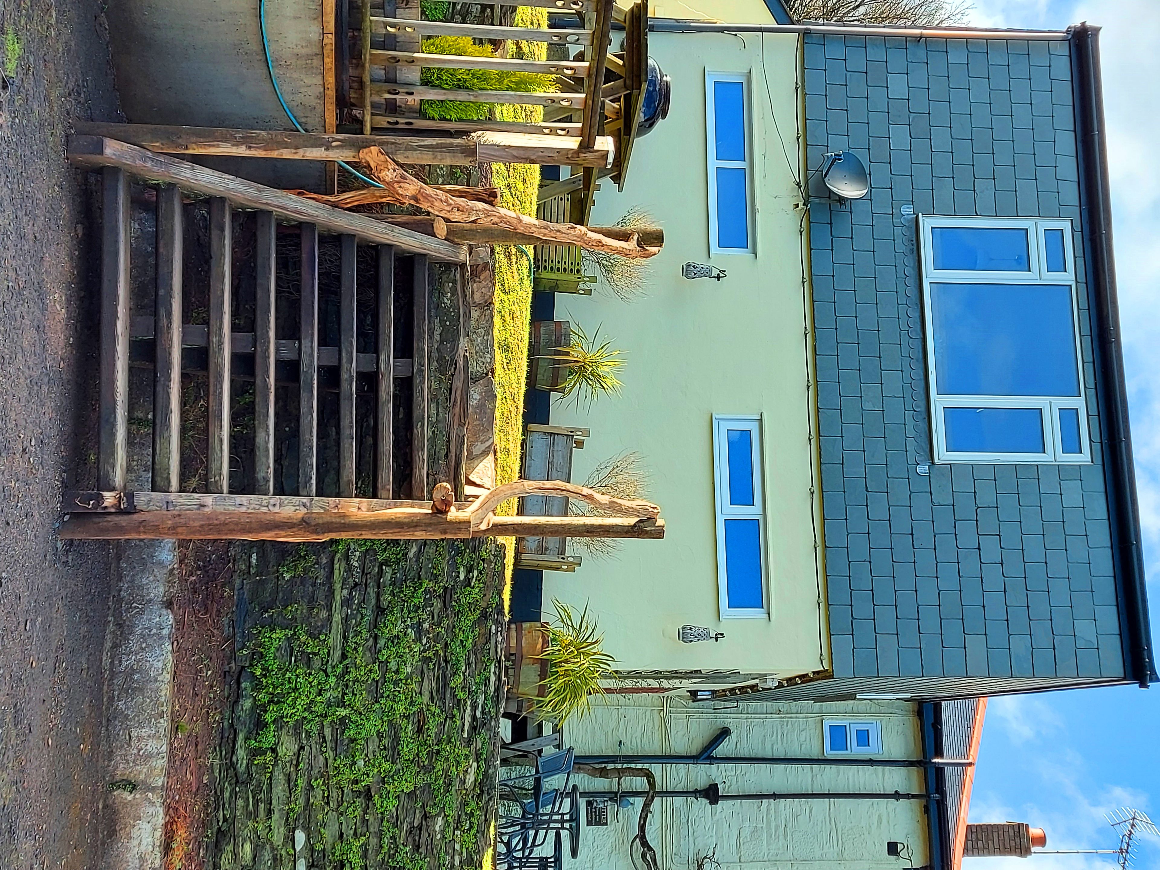 A residential building with a sloped roof, multiple windows, and a visible chimney.