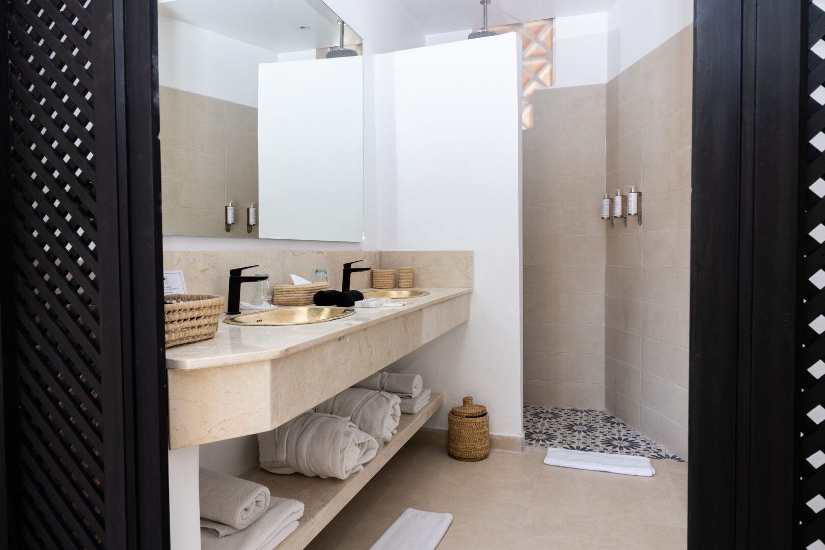 A modern bathroom with a vanity, towel rack, and shower area.