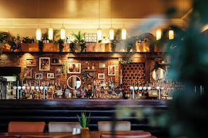A bar area with a brick wall, shelves of bottles, and hanging lights. - Duke Of Edinburgh Hotel (Barrow-in-Furness)