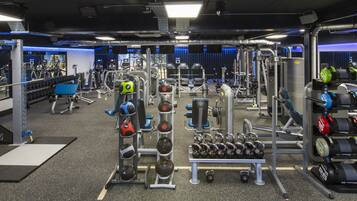 Une salle de sport équipée de divers appareils d’entraînement, notamment des appareils de musculation, des poids libres et des appareils de cardio.