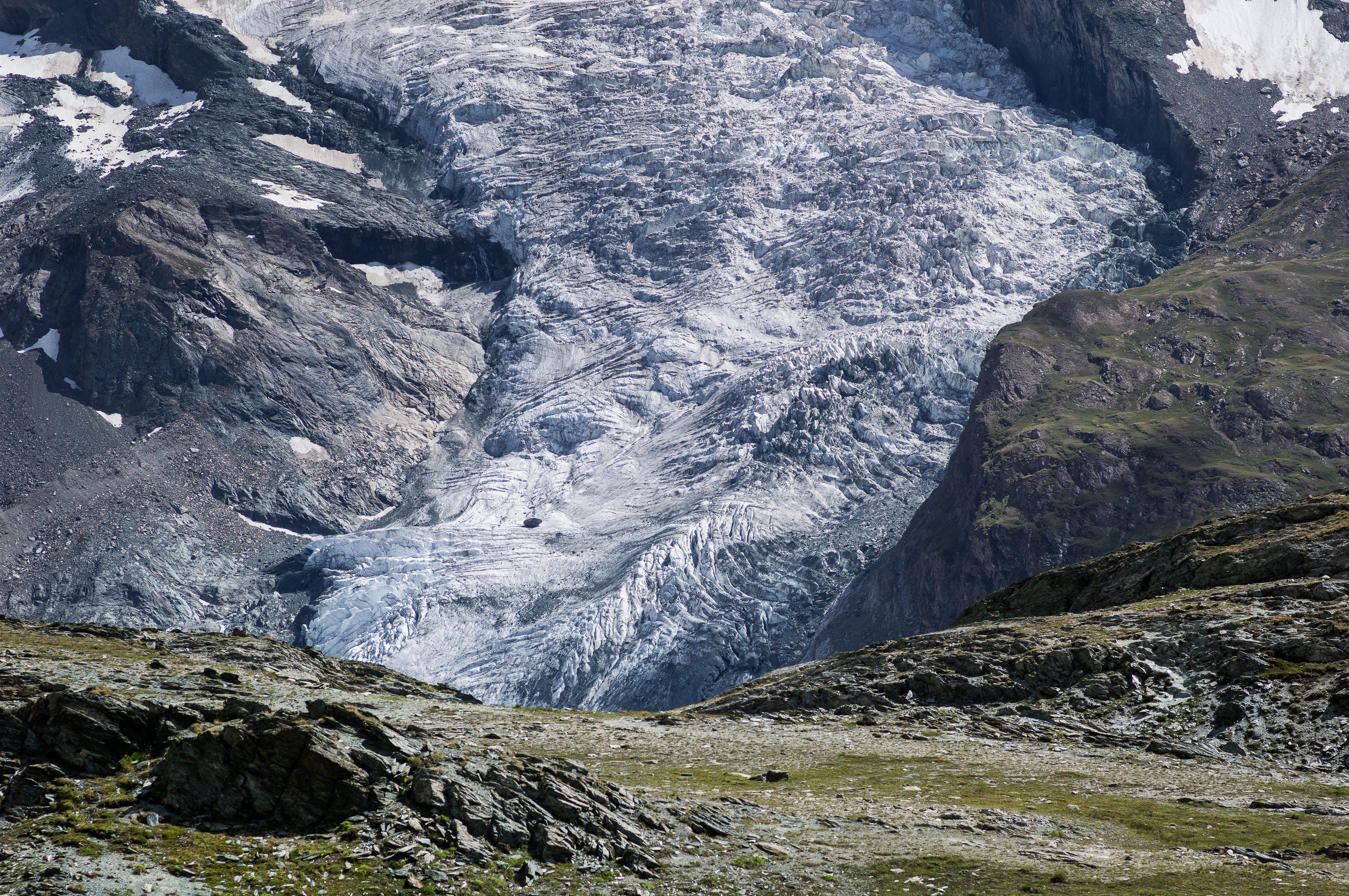 Un glaciar con terreno accidentado y vegetación escasa.
