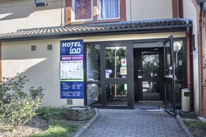 A hotel entrance with a signboard, glass doors, and a paved pathway leading to the entrance. -  Hôtel Inn Design Restaurant Bourges (Bourges)