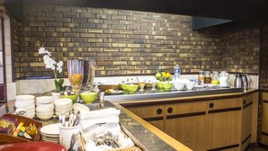 Een buffetopstelling met verschillende soorten eten en bestek.