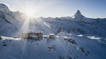 A snow-covered mountain with a building featuring a dome and a smaller structure.