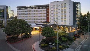 A Courtyard by Marriott hotel with a modern design, multiple floors, and a well-lit entrance.