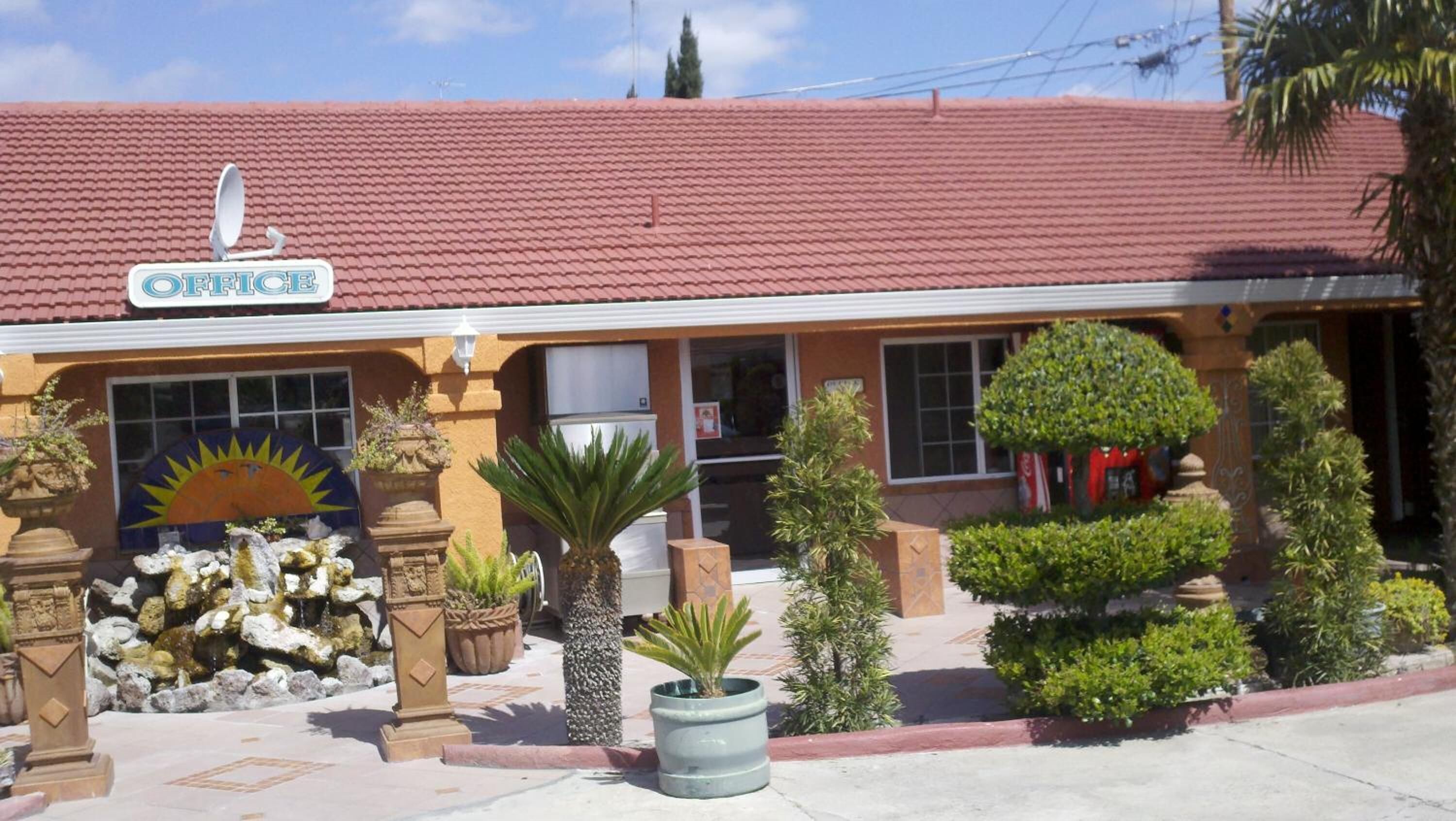A building with a red-tiled roof and a sign that reads "OFFICE".