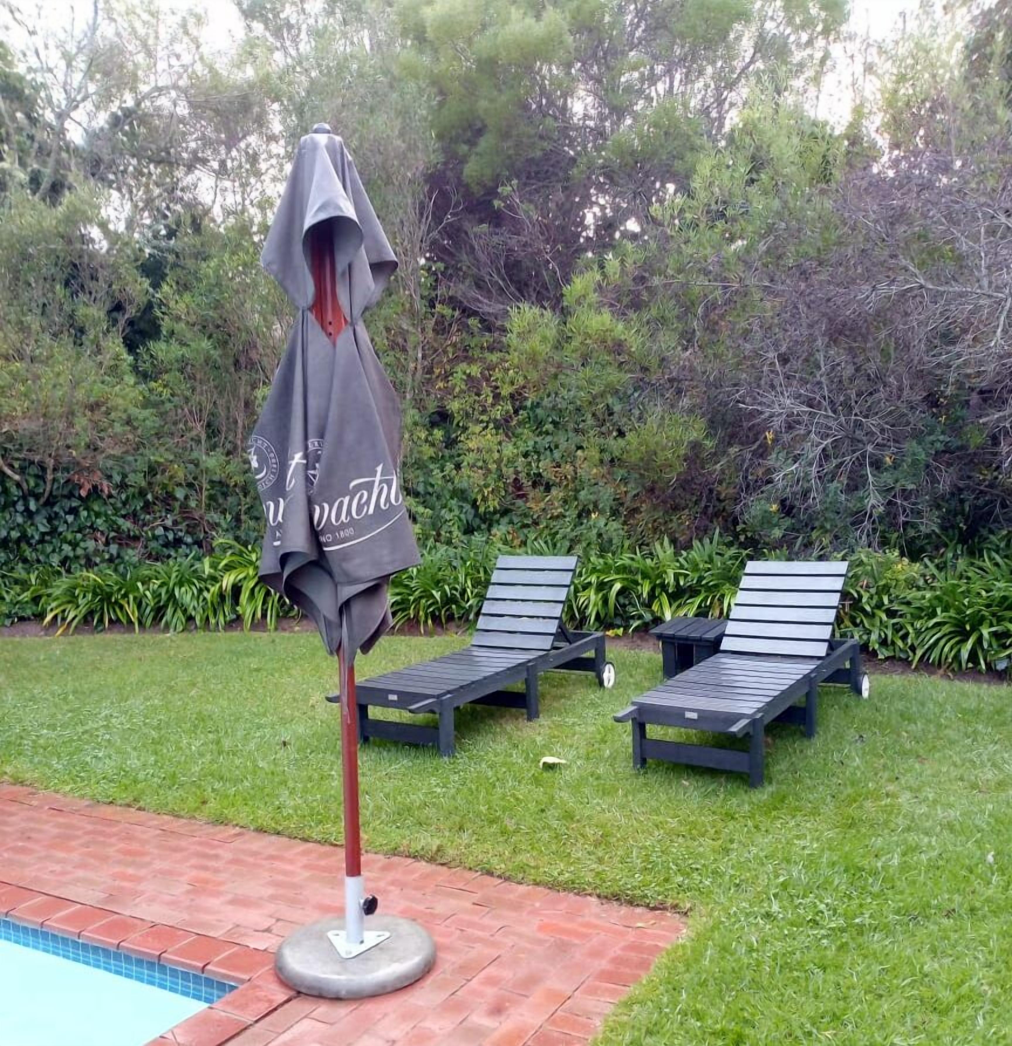 A poolside area with lounge chairs and an umbrella.