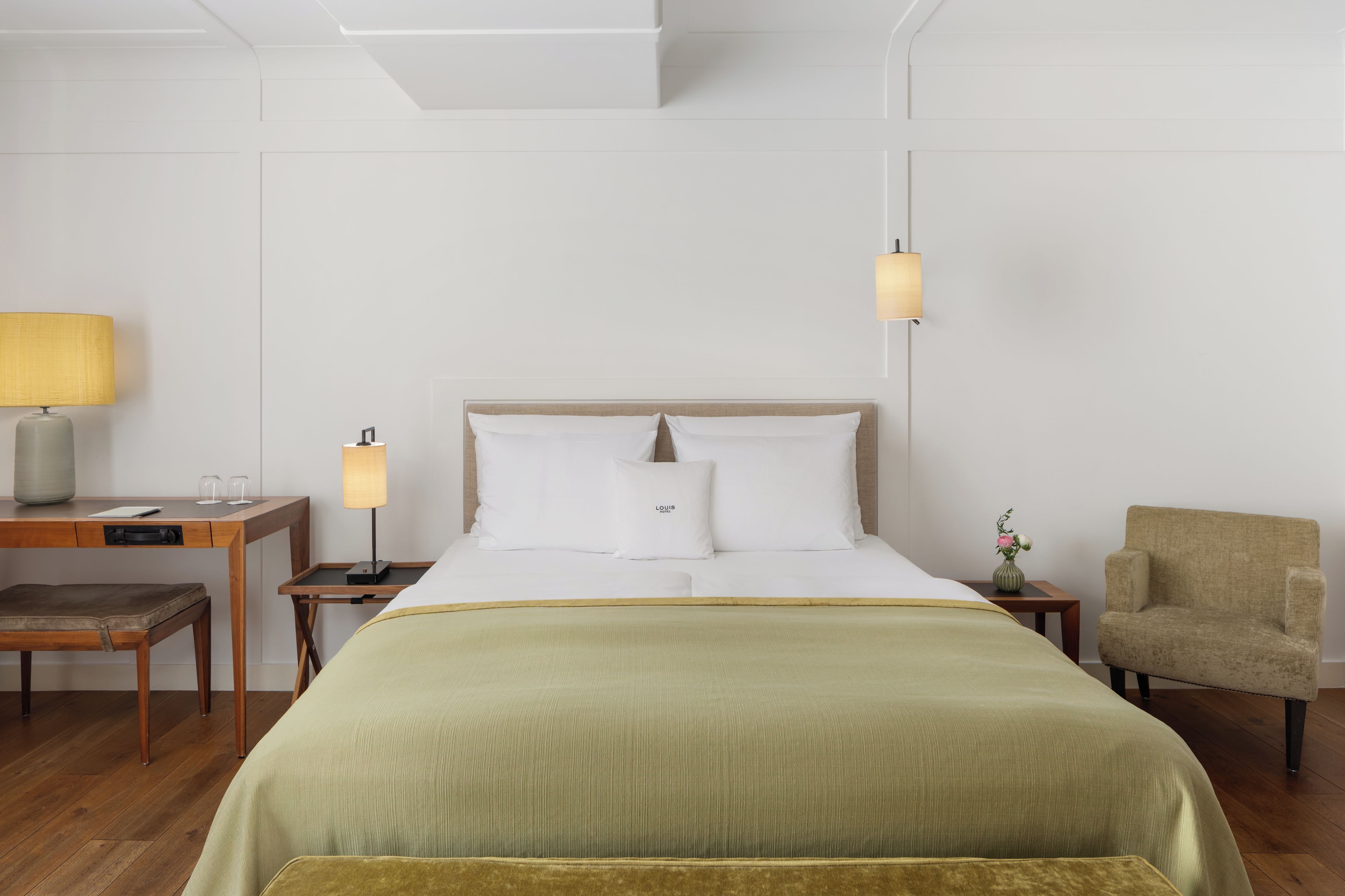 Une chambre d’hôtel comprenant un lit, des tables de chevet, un bureau, une chaise et une lampe.