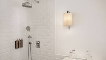 A modern bathroom with a shower, a towel rack, and toiletries.
