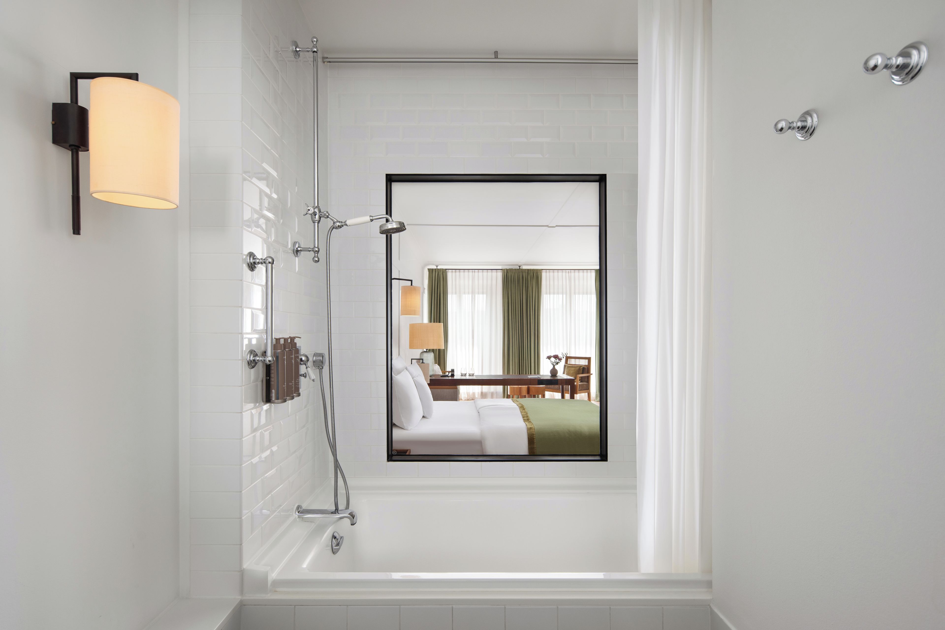 A modern bathroom with a bathtub, a shower, and a wall-mounted toilet.