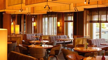 Enjoy dining and socializing in this inviting restaurant with round tables and cushioned chairs.