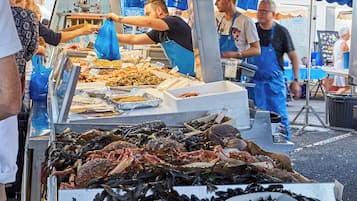 Un marché aux poissons et fruits de mer où différents types de produits sont présentés sur des étals.
