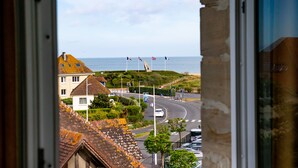 A coastal town with a roundabout, flags, and a view of the sea. - La Villa Andry (Ouistreham)