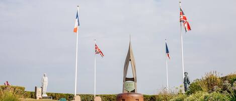 Ein Denkmal mit Flaggen, einer Statue und einem Monument.
