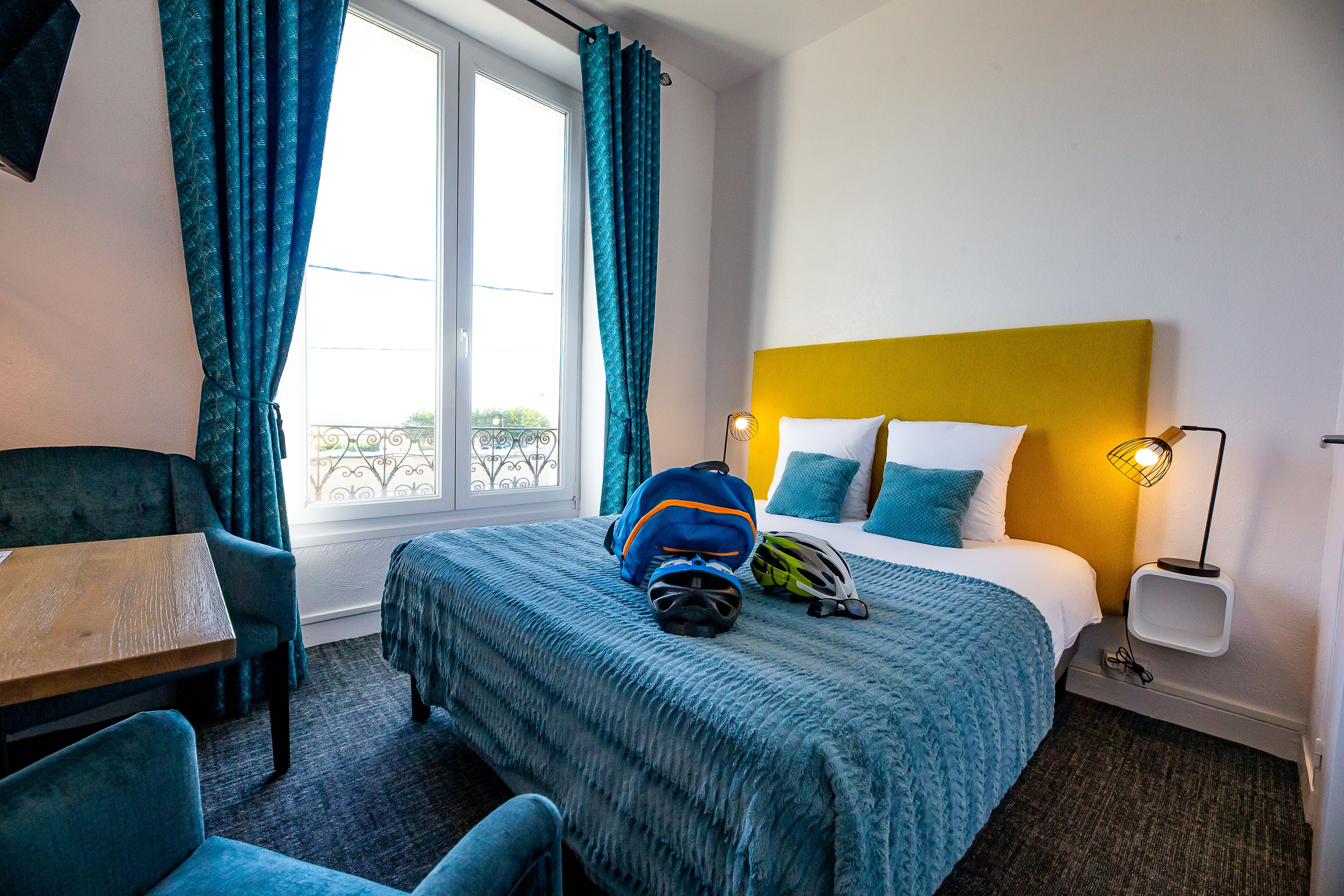 A hotel room with a bed, a table, and a chair.