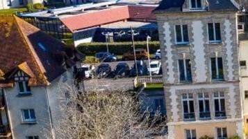 Un edificio de varios pisos con una torre destacada, edificios más pequeños adyacentes y un estacionamiento.