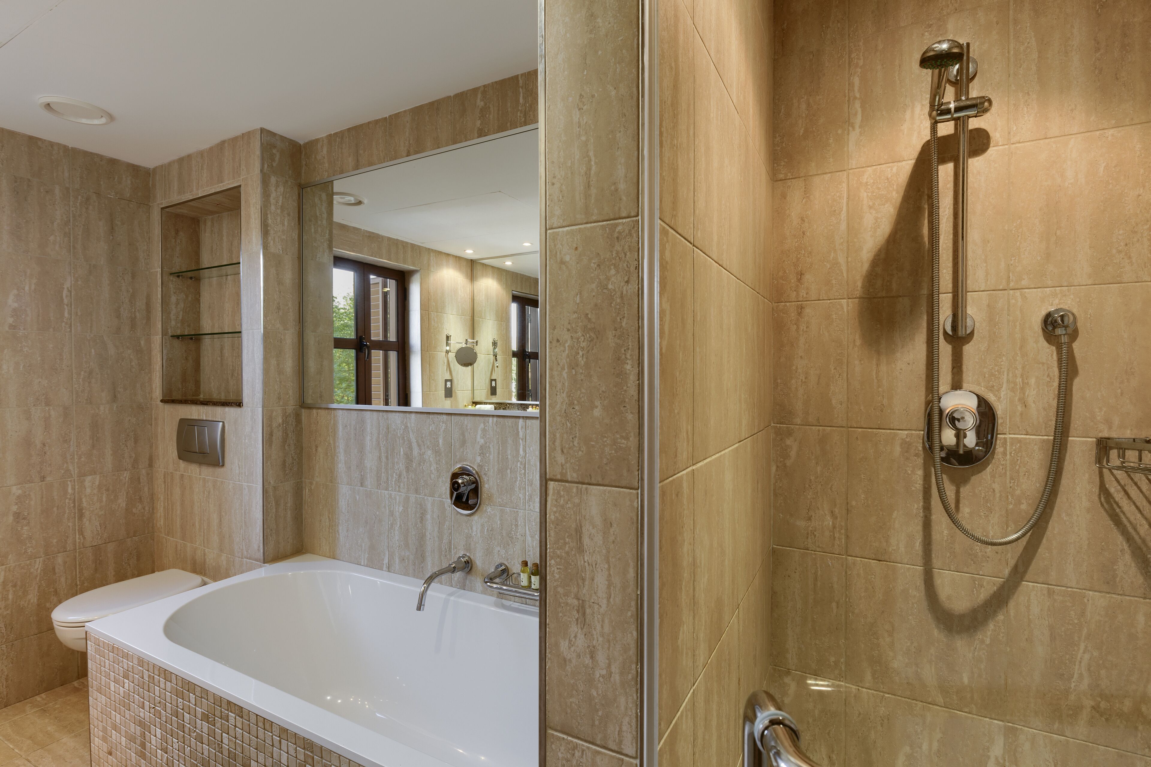 A modern bathroom with a freestanding bathtub, a walk-in shower, and a large mirror.